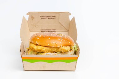 Calgary, Alberta, Kanada. 9 Mart 2023 'te açık bir kutunun önünde beyaz bir masada tavuk Big Mac burgeri vardı..
