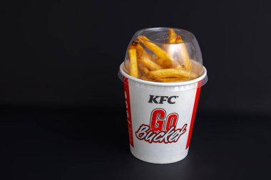 Calgary, Alberta, Kanada. 9 Mart 2023. Siyah arka planda patates kızartması olan bir KFC Go Bucket..