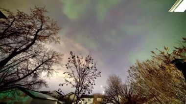 Geceleri auroras ya da kutup ışıkları olan bir mahalle topluluğu, perde, ışın, spiral ya da dinamik titreşimler gibi parlak ışıkların doğal ışık dinamik desenlerini gösterir..