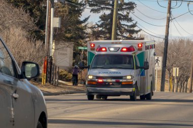 Calgary, Alberta, Kanada. Nisan 07, 2023. Işıklar açıkken yolda bir ambulans var..