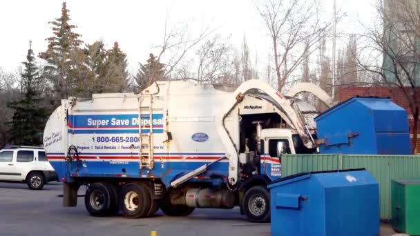 カルガリー アルバータ州 カナダ 2023年5月2日 廃棄物やリサイクルのためのゴミトラックは 大きな金属青のゴミ箱をロードします 廃棄物処理 — ストック動画