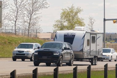 Calgary, Alberta, Kanada. 7 Mayıs 2023. Karavan ya da karavanı olan bir SUV minibüs, kampa gitmek için dağlara gidiyor..