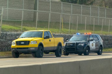 Calgary, Alberta, Kanada. 7 Mayıs 2023. Trafik polisi sarı bir kamyonu durduruyor. Konsept: hız cezaları