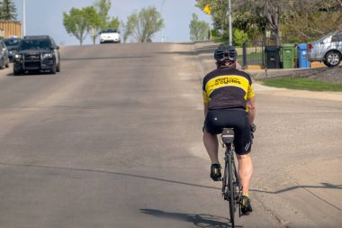 Calgary, Alberta, Kanada. 18 Mayıs 2023. Baharda yolda bisiklet süren biri..