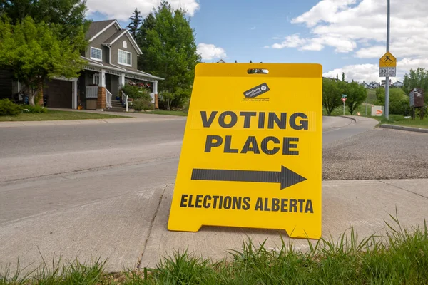 stock image Calgary, Alberta, Canada. May 29. 2023. front view of a Voting Place Elections Alberta sign, yellow double sided floor stand.