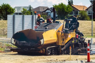 Calgary, Alberta, Kanada. 8 Haziran 2023. Yaz boyunca bir iş yerinde Tırtıl Asfalt Paver.