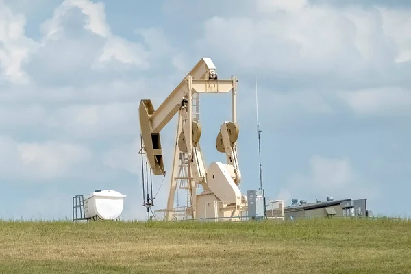A crude oil production well, a site with a pump jack in a rural area during summer in Alberta Canada. Concept: Oil And Gas Companies Cleanup Costs.