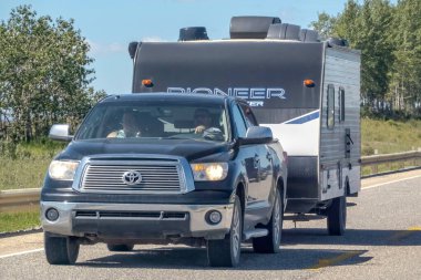 Cochrane, AB, Kanada. 13 Ağustos 2023. Bir karavan çekicisini çeken bir kamyonete yakın çekim. Yaz boyunca bir otoyolda..