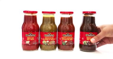 Calgary, Alberta, Kanada. Ağustos 24, 2023. Meksika sosu şişesi tutan biri. La Costea, Meksika 'dan popüler bir yiyecek markası..