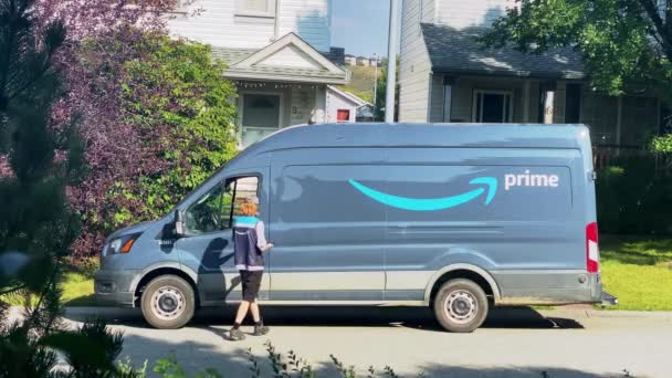 カルガリー カナダ 8月25日 2023年 バンを持つAmazonプライムワーカーは 郊外を巡るカルガリー通りに引っ張ってドアからドアにパッケージを配達します シームレスな配信を実現 — ストック動画