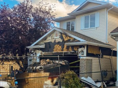 Calgary, Alberta, Canada. Sep 12, 2023. A close-up view of a neighborhood garage roof, which bears the scars of recent accidental fire damage, expertly extinguished by firefighters. clipart