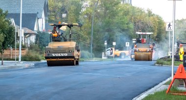 Calgary, Alberta, Kanada. Sep 10, 2023. İki asfalt asfalt kaldırım makinesi yeni döşenmiş kaldırımı sıkıştırıyor. Kavram: Çukurun Tamiri, Asfalt Tamiri ve Bakımı