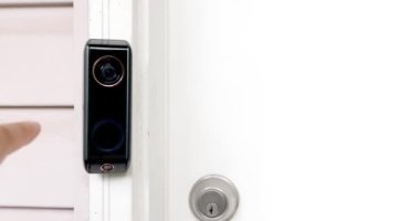 Ev girişinde dahili telefonu ve çift kameralı akıllı kapı zili kullanan biri..