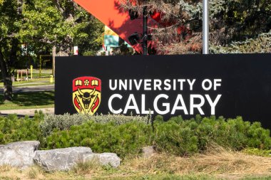Calgary, Alberta, Kanada. Sep 16, 2023. Calgary Üniversitesi 'nin ana giriş tabelasına yakın bir yerde yazın ihtişamıyla çevrili..
