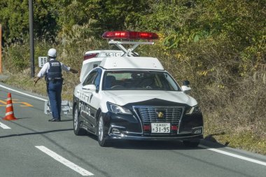 Yamanakako, Yamanashi Bölgesi, Japonya. 5 Kasım 2023. Acil bir durum sırasında bir polis arabası ve bir memur otobanda..