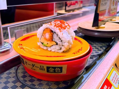 Tokyo, Japonya. 23 Aralık 2023. Küçük bir tabakta tek parça ıstakoz suşi rulosu..