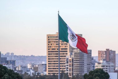 Mexico City, Meksika. 11 Ocak 2024. Mexico City şehir merkezinde bir kış öğleden sonra, büyük bir Meksika bayrağı zarif bir şekilde rüzgarda dalgalanıyor..