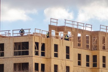 Calgary, Alberta, Kanada. 17 Şubat 2024. Kış mevsiminde ahşap yapıların yer aldığı inşaat sürecinde bir apartman kompleksi..