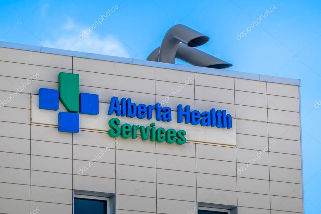 Calgary, Alberta, Canada. Feb 15, 2024. An Alberta Health Services sign at the top of a Cancer Centre hospital building in Calgary.