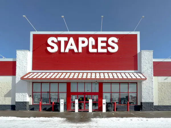 Calgary, Alberta, Kanada. 25 Şubat 2024. Kışın ortasında bir Staples mağazasının giriş yapısı, açık mavi bir gökyüzünün zeminine karşı kurulur..