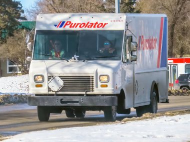 Calgary, Alberta, Kanada. Mar 6, 2024. Güneşli bir kış gününde yola çıkan bir Purolator nakliye kamyonu..