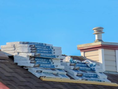 Calgary, Alberta, Kanada. Mar 17, 2024. Tone Black Bp Kanada Mistik Fiberglas Çatı Kirişleri 'nin çoklu demetleri yerleştirilmeyi bekleyen bacanın yanındaki bir evin tepesinde..