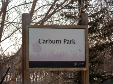 Calgary, Alberta, Kanada. 11 Nisan 2024. Calgary 'nin güneydoğusunda bir Carburn Park tabelasında göl, lagün, patikalar, banklar, piknik masaları ve açık hava buz pateni pisti var..