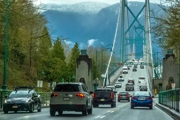 Vancouver, British Columbia, Kanada. 12 Nisan 2024. Yağmurlu bir günde, kalabalık trafiğin ortasında araçlarla Lions Gate Köprüsü..