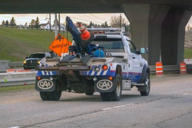 Calgary, Alberta, Canada. Apr 24, 2024. The back side of an AMA or CAA Alberta Motor Association tow truck on the road. clipart