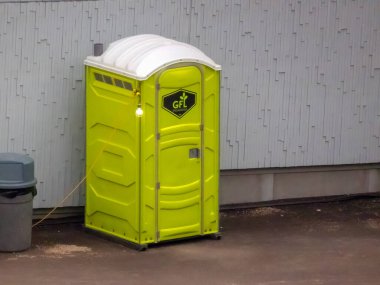 Calgary, Alberta, Kanada. 10 Mayıs 2024. İnşaat alanında yeşil taşınabilir tuvalet..