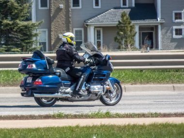 Calgary, Alberta, Kanada. 11 Mayıs 2024. Motosikletli güpegündüz güzergah değiştiriyor. Etkili seyahat kipi.