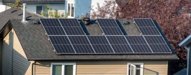 Calgary, Alberta, Kanada. 7 Ağustos 2024. Kiremitler boyunca simetrik olarak düzenlenmiş, güneş ışığını maksimum seviyede tutmak için etkin bir şekilde yerleştirilmiş çoklu güneş panelleriyle donatılmış bir yerleşim çatısı..