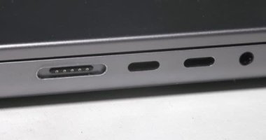 Calgary, Alberta, Kanada. 10 Ağustos 2024. Gece görünümü sırasında MagSafe güç portu ile MacBook Bilgisayarını yükleyen bir kişi.