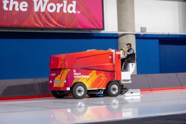 Calgary, AB, Kanada. 12 Ağustos 2024. Kırmızı Zamboni makinesi kullanan bir kişi buz pateni için bir buz yüzeyi hazırlar, Calgary Üniversitesi logosu belirgin bir şekilde sergilenir.