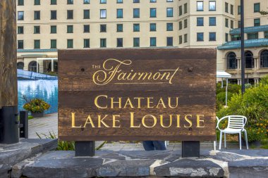 Louise Gölü, AB, Kanada. 26 Ağustos 2024. Fairmont Chateau Lake Louise tabelası, altın harfli ahşap tabela, otelin etkileyici mimarisinin bir zemininde duruyor..