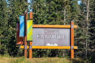 Canmore, AB, Kanada. 26 Ağustos 2024. Modern bir tasarıma sahip bir karşılama tabelası Canmore, Alberta 'ya ziyaretçileri karşılıyor. Tabelada kasabanın adının yazılı olduğu metal bir plaket ve çevrenin bir tasviri yer alıyor..