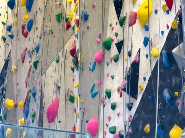 Renkli tutacakları olan canlı bir tırmanma duvarı, dağcıları yeteneklerini test etmeye ve yeni yüksekliklere ulaşmaya davet ediyor..