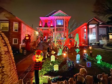 Calgary, Alberta, Kanada. 2 numara, 2024. Cadılar Bayramı için evlerin süsleri ürkütücü dekorasyonlar, renkli ışıklar ve bahçedeki ürkütücü figürlerle dolu. Sahne bir şenlik yaratır.