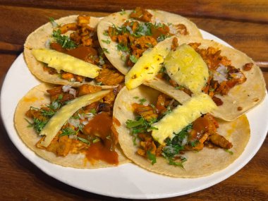 Her biri sulu marine edilmiş domuz eti, ananas, soğan, kişniş ve salsa sosuyla dolu altı tabak papaz tacosu..