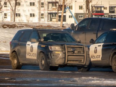 Calgary, Alberta, Kanada. 10 Aralık 2024. İki Calgary Polis Servisi aracı kış sokağına park edilmiş, halka hizmet etmeye hazır.. 
