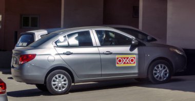 Los Cabos, B.C.S., Meksika. Aralık 18, 2024. Üzerinde OXXO logosu olan gümüş bir Chevrolet Yelkenlisi, bir marketin önüne park edilmiş..