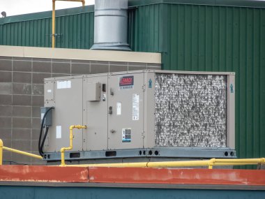 Calgary, Alberta, Kanada. 18 Ocak 2025. Lennox ticari çatı katı havalandırma ünitesi bir binanın tepesinde, metal kaplaması ve karmaşık yoğunlaştırıcı bobinleri görünür..