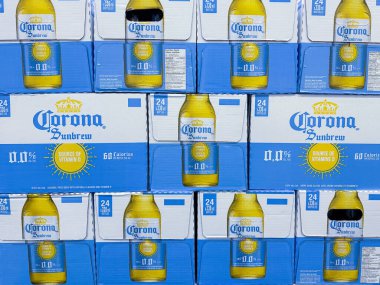 Calgary, Alberta, Kanada. 24 Ocak 2025. Birkaç kasa Corona Sunbrew ve alkolsüz biranın yakın çekimi. Şişeler şebeke şeklinde istiflenmiş, mavi ve sarı işaretleri gösteriyor..