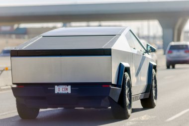 Calgary, Alberta, Kanada. 25 Ocak 2025. Tesla Cybertruck, Tesla tarafından üretilen keskin, açısal tasarım ve metalik kaplamalı bir elektrikli pikap, otoyolda giderken görülüyor..