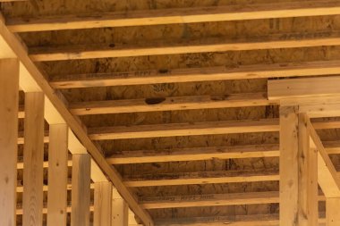 Yeni yapılmış ahşap çerçeveli bir tavan, binanın yapısal elementlerinin gücünü ve hassasiyetini gösteriyor..