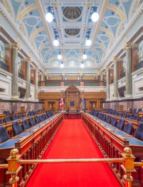 Victoria, British Columbia, Canada. Feb 10, 2025. Opulent interior of the BC Parliament Building Legislative Chamber in Victoria, featuring tiered seating, ornate vaulted ceilings, and a red carpet. clipart