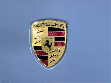 Victoria, British Columbia, Kanada. 14 Şubat 2025. Açık mavi bir yüzeye yakın plan bir Porsche amblemi, ikonik at ve 