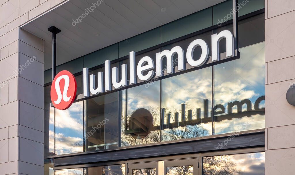 Victoria, British Columbia, Canada. Feb 14, 2025. Lululemon storefront with prominent logo and clear signage against a light stone facade, reflecting the sky and trees in the glass.