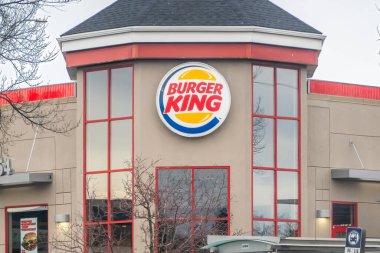 Vancouver, British Columbia, Kanada. 10 'a yakın, 2025. Ön cephesinde belirgin bir logosu olan Burger King restoranında kırmızı aksanlı ve geniş pencereli bej bir bina var..