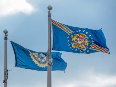 Calgary, Alberta, Kanada. 12. kat, 2025. Bayrak direğinde dalgalanan iki mavi bayrak. Biri Calgary Polis Servisi 'ni temsil ediyor, diğeri de Calgary Acil Yardım Servisi için..